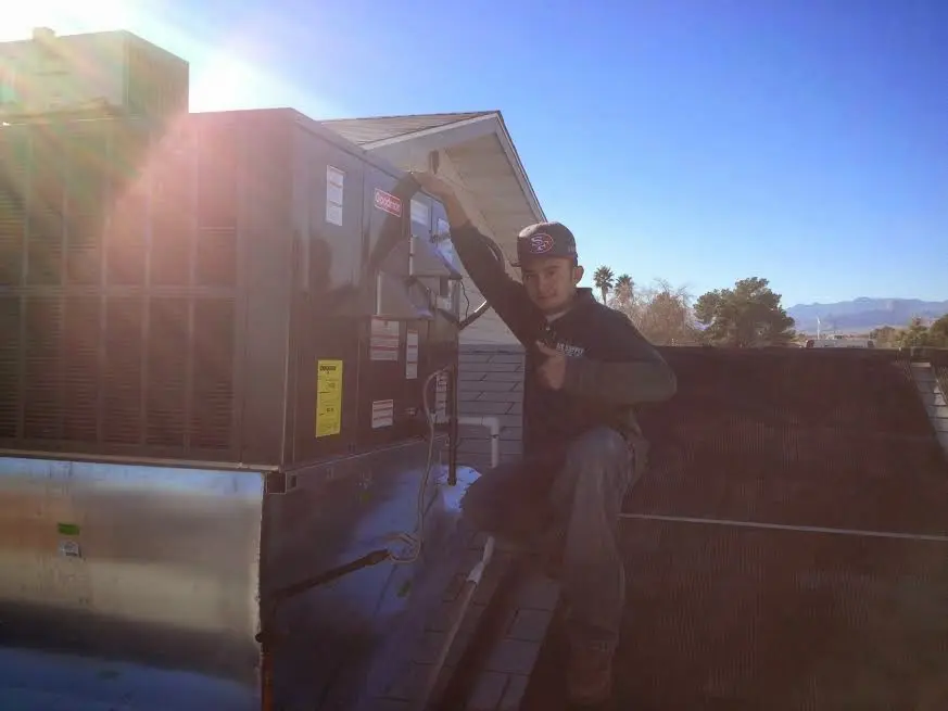 HVAC technician performing Air Duct Cleaning on a rooftop unit in Prichard